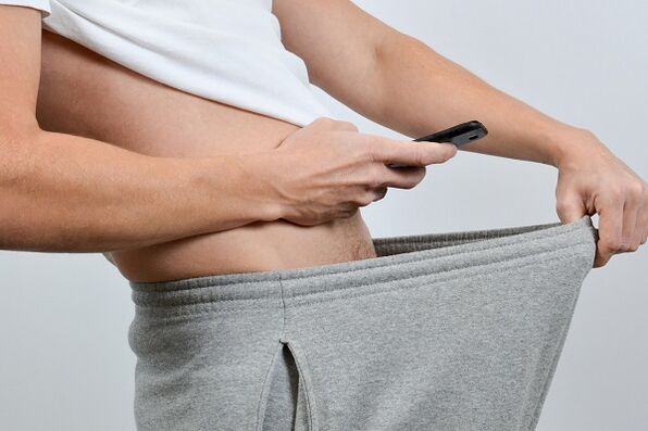 un home mira para abaixo dos seus pantalóns un pene agrandado